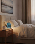 Blue faceted crystal night lamp glowing on a wooden nightstand in a warm bedroom