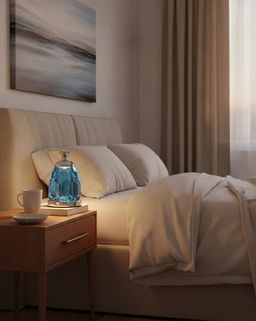 Blue faceted crystal night lamp glowing on a wooden nightstand in a warm bedroom