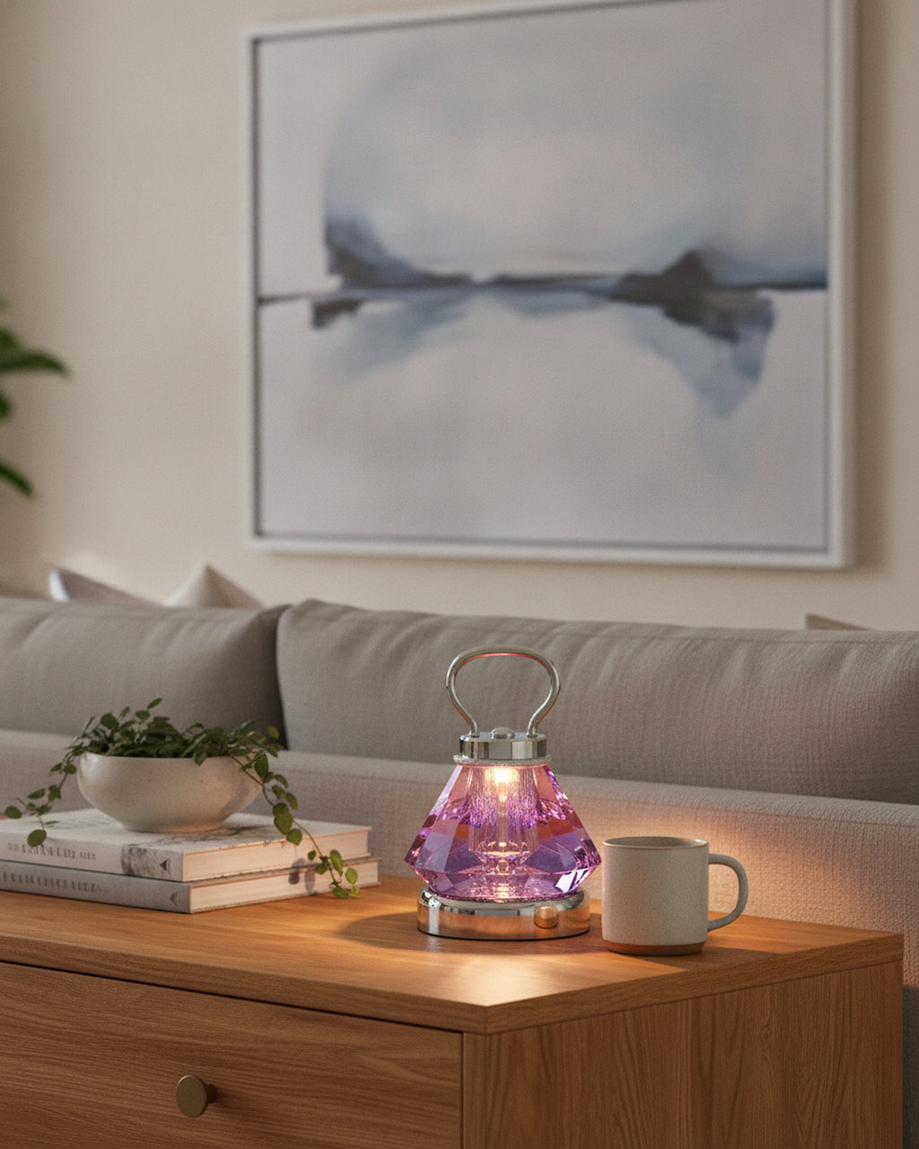 Purple faceted crystal lamp on an oak sideboard with art books