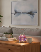 Purple faceted crystal lamp on an oak sideboard with art books
