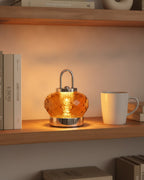 Amber crystal night lamp on a wooden bookshelf between books