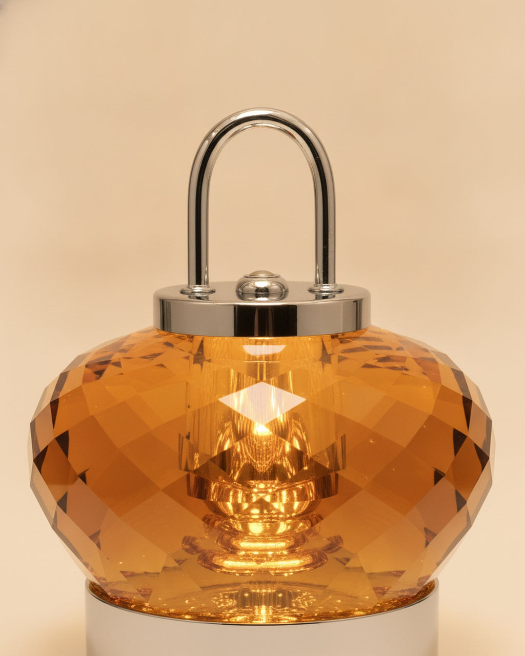 Close-up of the faceted amber K9 crystal body, polished chrome handle and cap