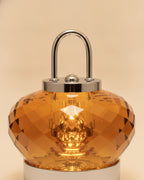 Close-up of the faceted amber K9 crystal body, polished chrome handle and cap
