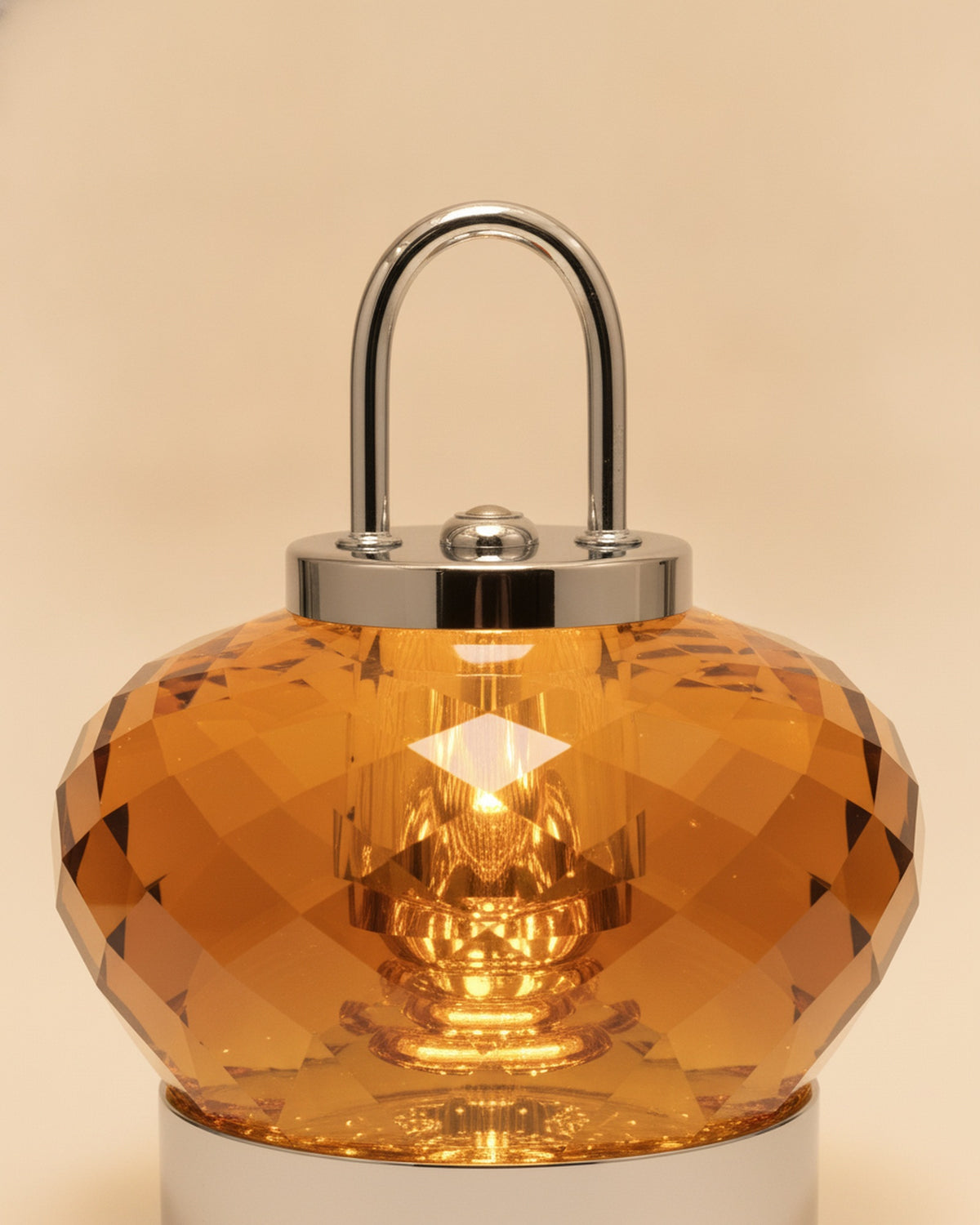 Close-up of the faceted amber K9 crystal body, polished chrome handle and cap